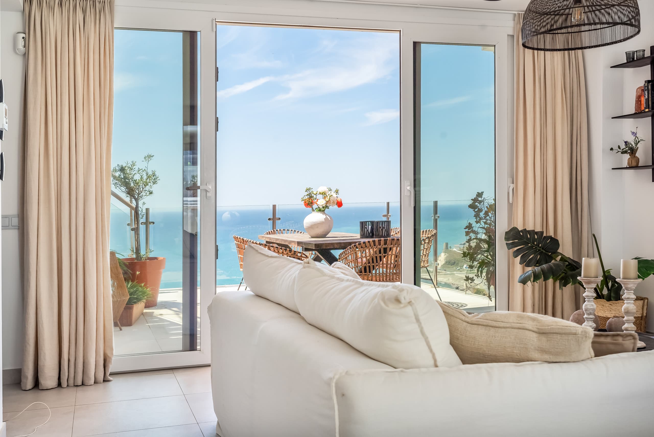 Living room sofa with terrace doors open to the sea